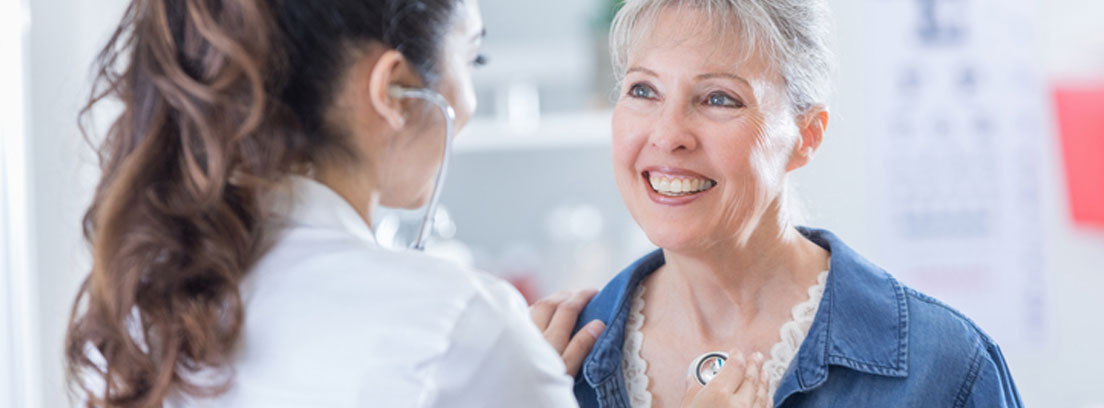 Médico oscultando a mujer mayor.