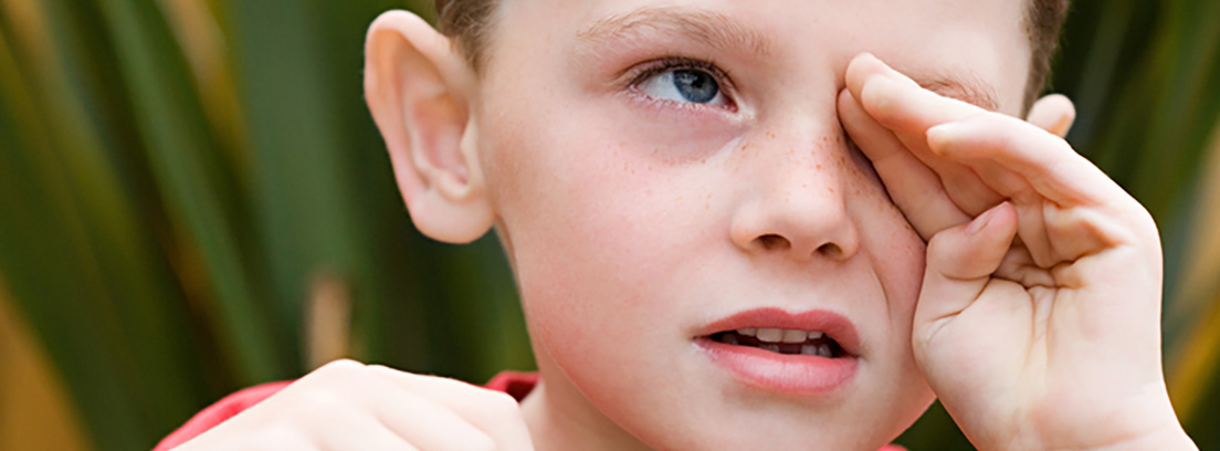 Niño se rasca un ojo