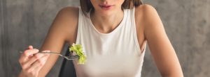 mujer intentando comer una ensalada