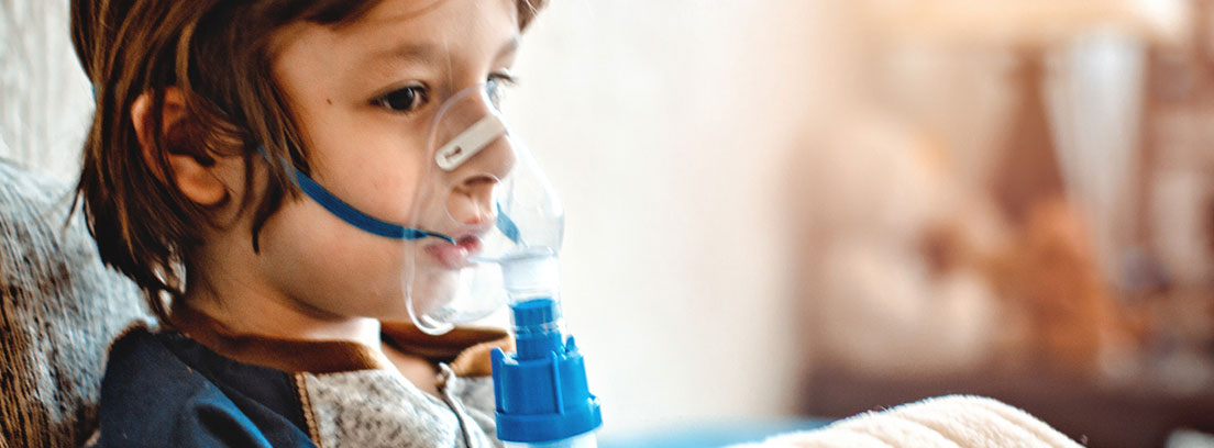 Niño mayor con problemas utilizando un aparato para respirar mejor