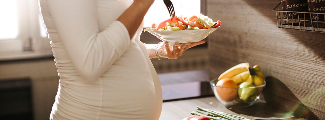 Mujer embarazada comiendo una ensalada