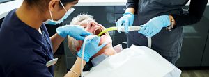 Dentista trabajando en la boca de un señor