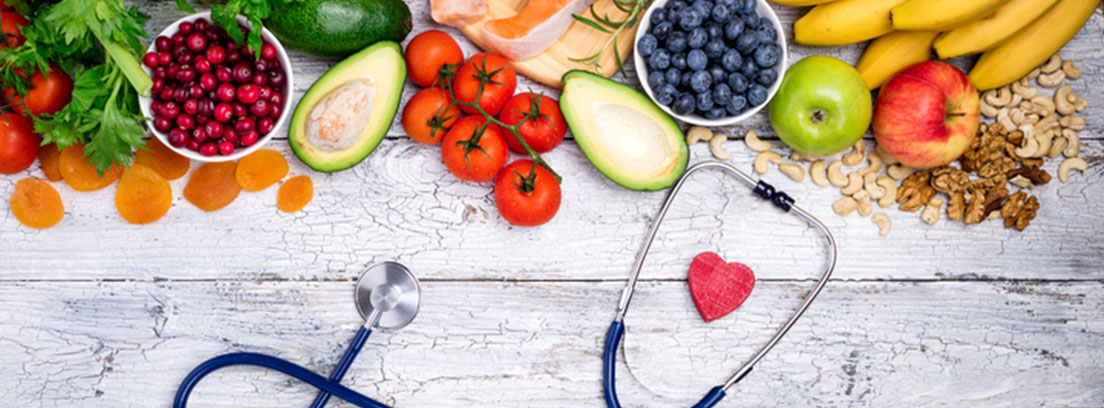 Fonendoscopio junto con alimentos como el tomate, el aguacate, los arándanos...