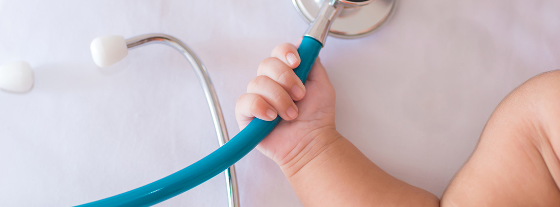 Mano de un bebé agarrando un aparato médico
