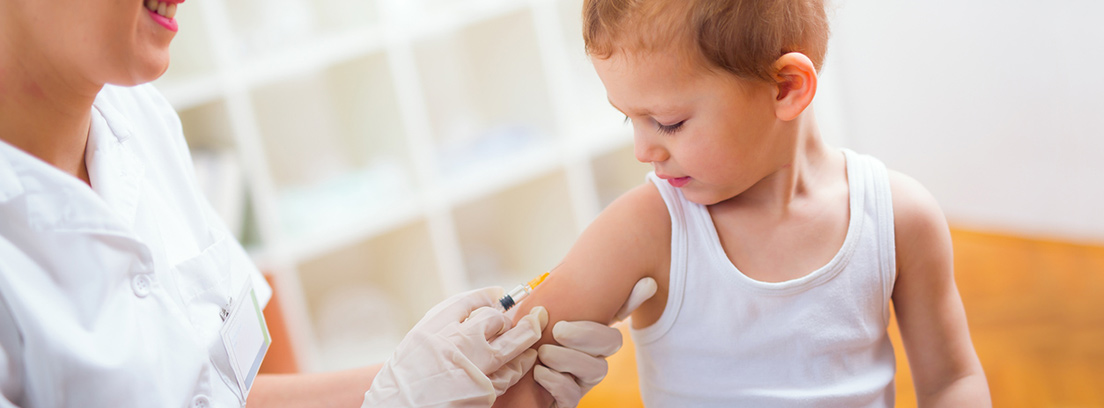 Médico pinchando a un niño en el brazo