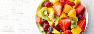 Ensalada de frutas con trozos de kiwi, naranja, fresa, arándanos y uvas