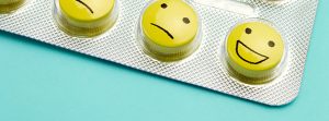 Blister de pastillas con caras (triste, seria y sonriente) dibujadas