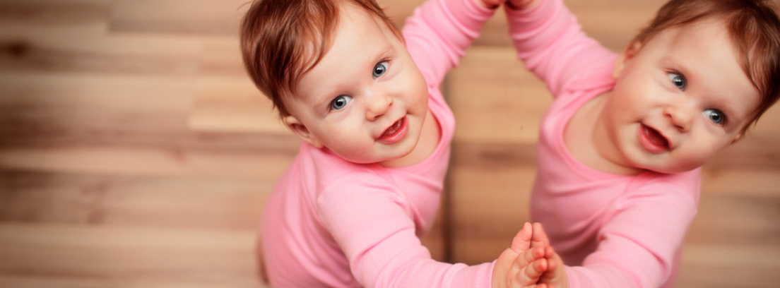 Niña tocando un espejo y mirando hacia arriba