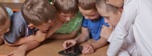 Grupo de niños jugando con una tablet