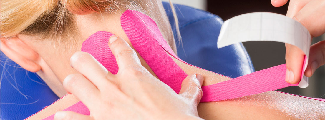 Una persona le pone a otra unas pegatinas de color rosa en el cuello