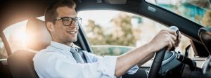 Hombre con gafas conduciendo un vehículo