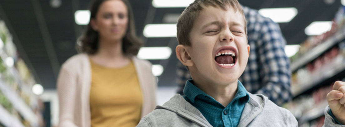 Niño en plena rabieta dando la espalda a sus padres