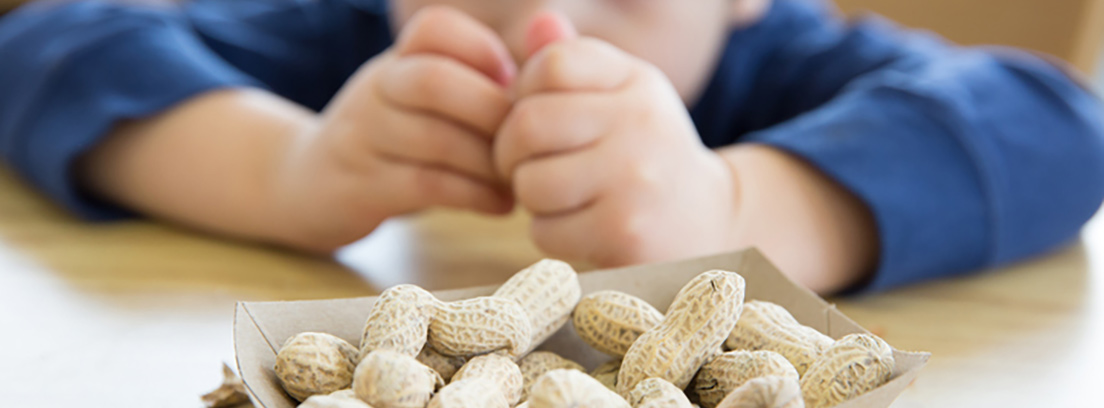 Manos de un niño abriendo un cacahuete