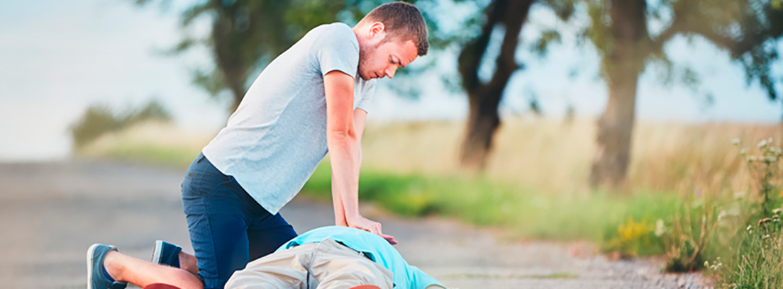 Hombre en el suelo siendo reanimado por un hombre