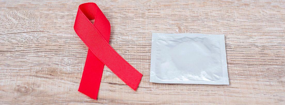 SIDA, Cinta Roja y condón sobre fondo de madera 