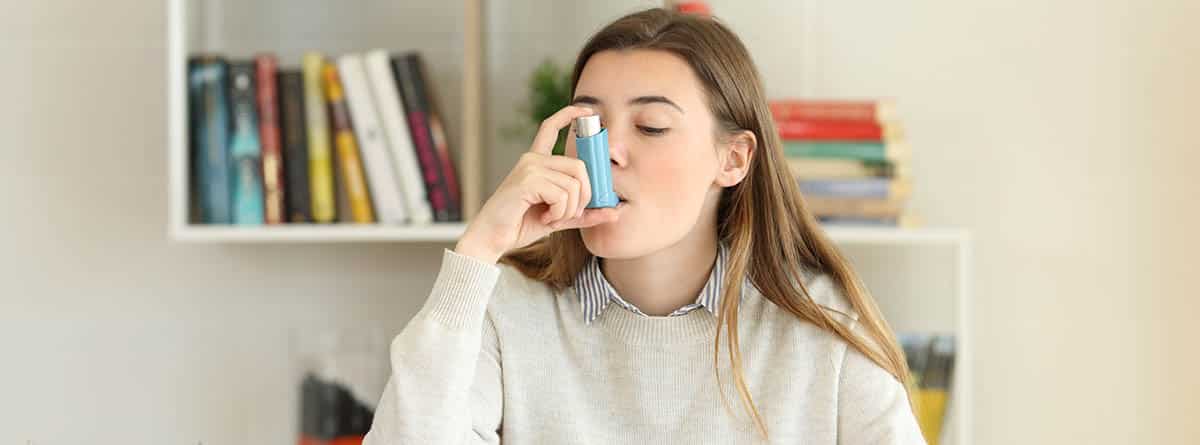 Asma, síntomas y tratamiento: chica joven con un inhalador para el asma