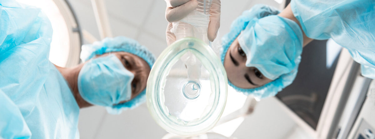 Anestesia en personas mayores: dos médicos en quirófano con una mascarilla anestésica