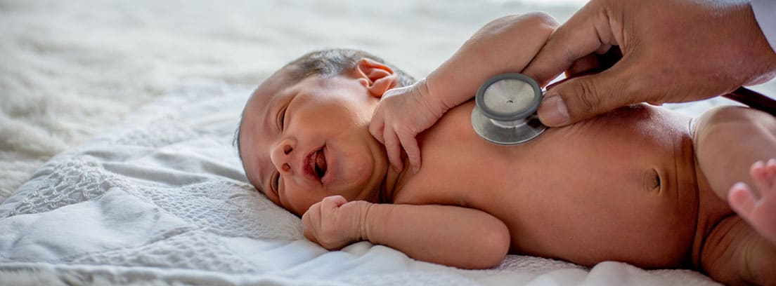 Neumonía congénita del recién nacido: Médico con un estetoscopio obscultando a bebé