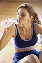 mujer con ropa deportiva bebiendo agua