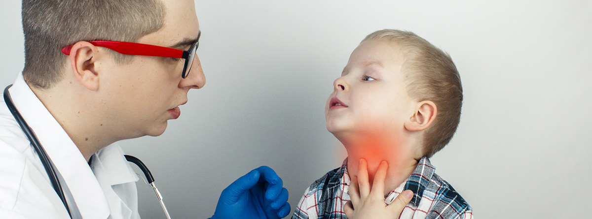 Traqueítis: doctor observando el cuello de un niño