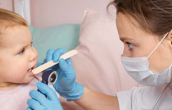 Traqueitis aguda: pediatra mirando la garganta de un niño