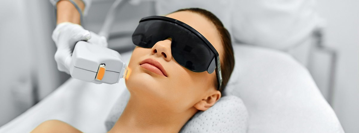 Mujer con gafas haciéndose un tratamiento en la cara con laser