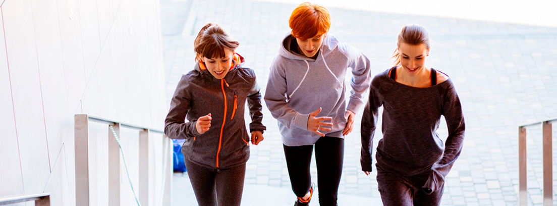 3 mujeres subiendo una escalera corriendo