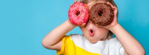 dos niños mordiendo un donuts de fresa