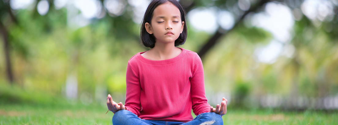 niña practicando meditación al aire libre