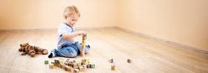 niño sentado en el suelo jugando con cubos de madera