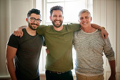 tres hombres abrazados sonriendo