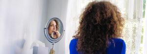 mujer mirándose al espejo con cara de peocupación