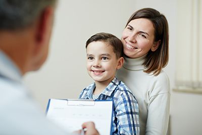 médico asistiendo al niño con su madre