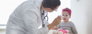 Medico revisando niña los ojos