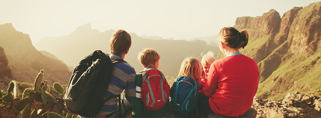 Una familia observando el paisaje desde la cima de una montaña