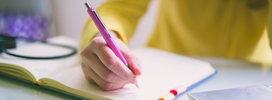 mano con un bolígrafo escribiendo en un cuaderno