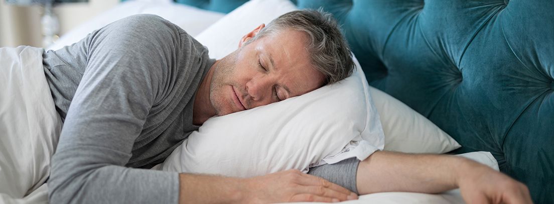 hombre durmiendo de lado con el brazo debajo de la almohada