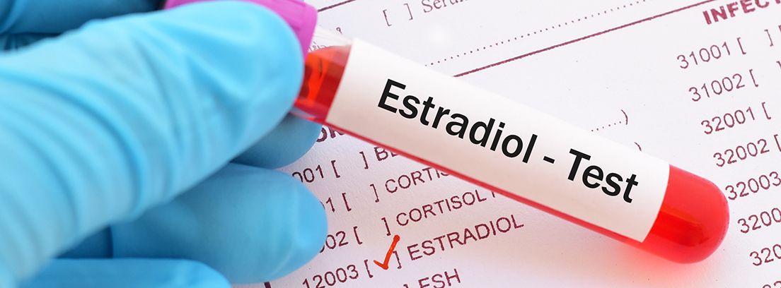 tubo de ensayo con el test de estradiol encima de tabla de valores