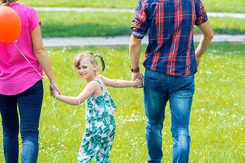 padres e hija paseando por el campo