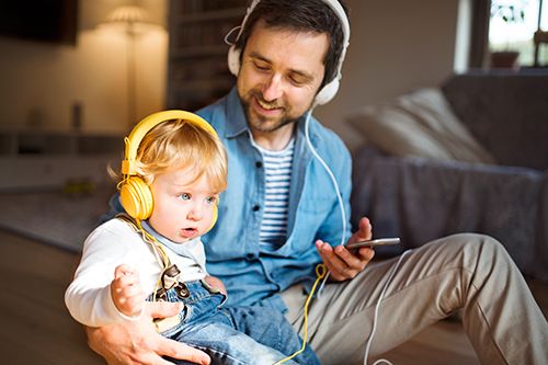 hombre y bebé escuchando música con auriculares