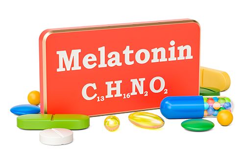 caja de metal roja de melatonina y diferentes pastillas alrededor