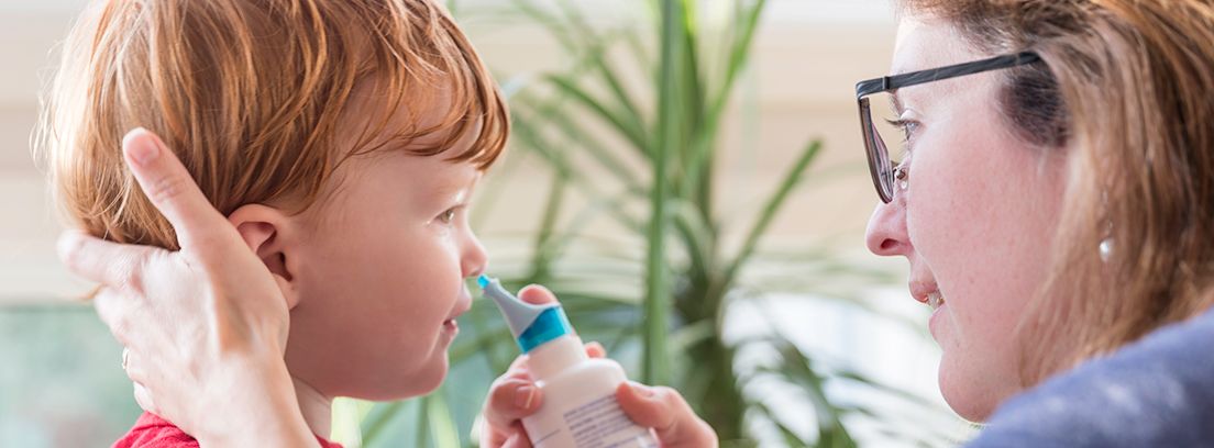 mujer realizando un lavado nasal a un niño