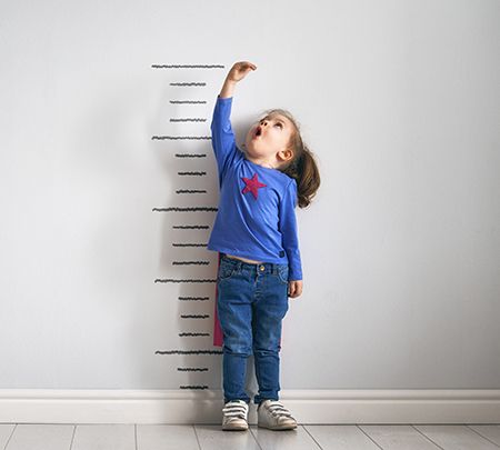 niña midiéndose la altura en una pared