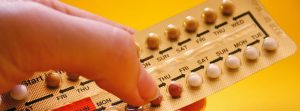 dedos sujetando una tableta de minipíldoras anticonceptivas