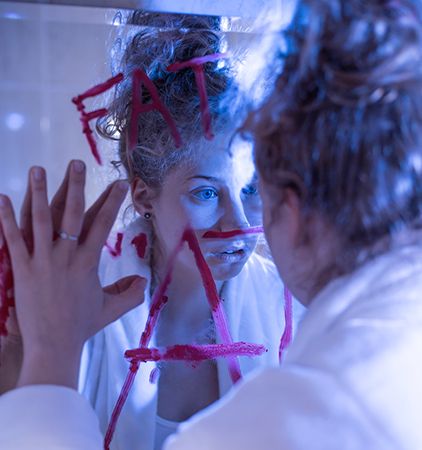 mujer con las manos apoyadas en la pared con unas letras dibujadas