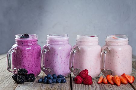 yogures de sabores en jarras con frutas a los lados