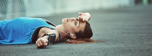 mujer deportista tumbada en el suelo por fatiga