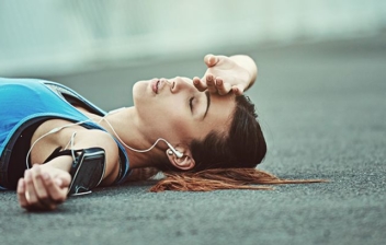 mujer deportista tumbada en el suelo por fatiga