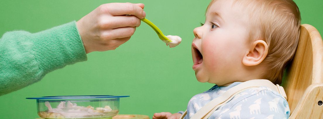 dando de comer a un bebé con una cuchara