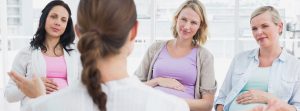 doula conversando con tres mujeres embarazadas